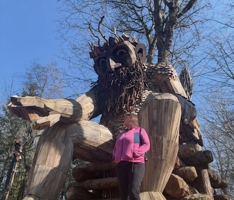 Explorer Sue in front of Oscar the Bird King troll at Point Robinson Park on Vashon Island, Washington.